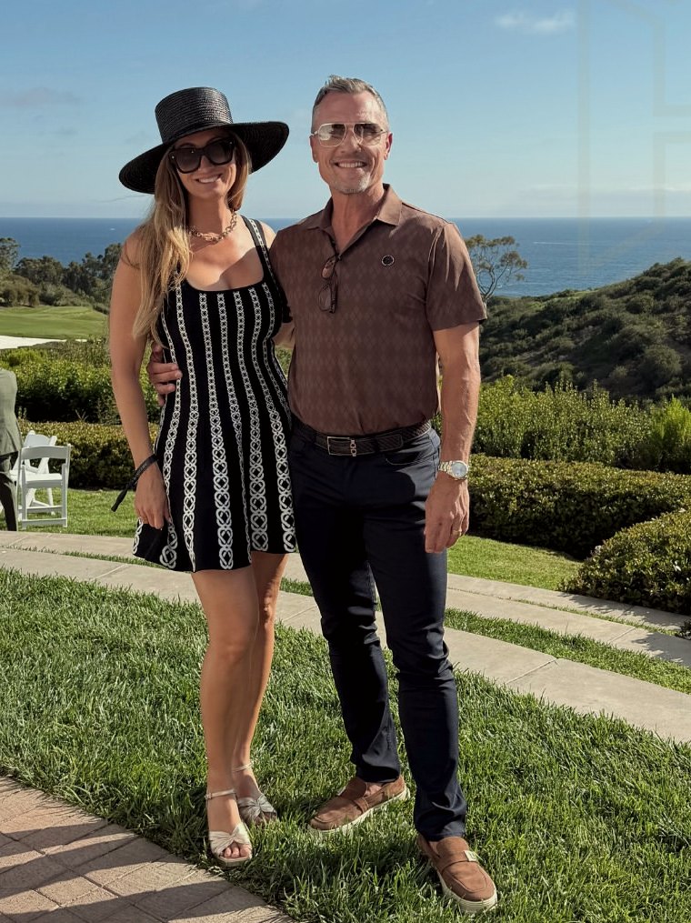 Ross and Erin Murray standing on a coastal lawn above the Pacific